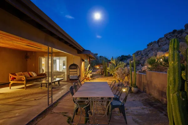 a view of a patio with table and chairs with wooden floor and fence