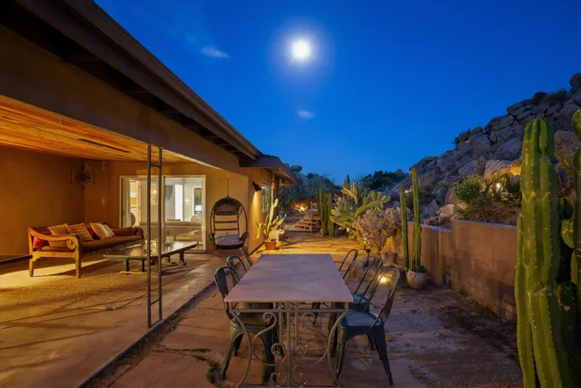 a view of a patio with table and chairs with wooden floor and fence
