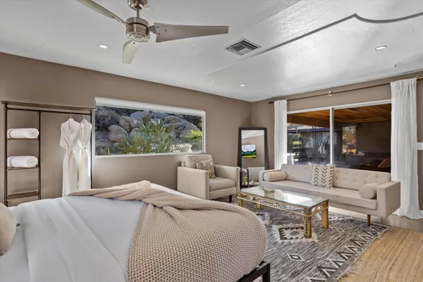 a bedroom with a bed a large window and couch