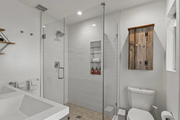 a bathroom with a sink a toilet and shower