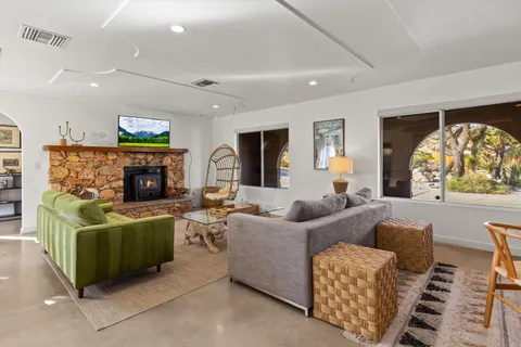 a living room with furniture a flat screen tv and a fireplace
