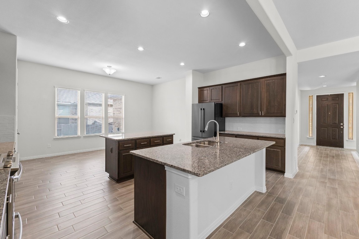 104 Scenic Hills Circle Georgetown, TX 78628 - Photo 11 of 30 a kitchen with stainless steel appliances granite countertop a sink dishwasher a stove and a refrigerator with wooden floor