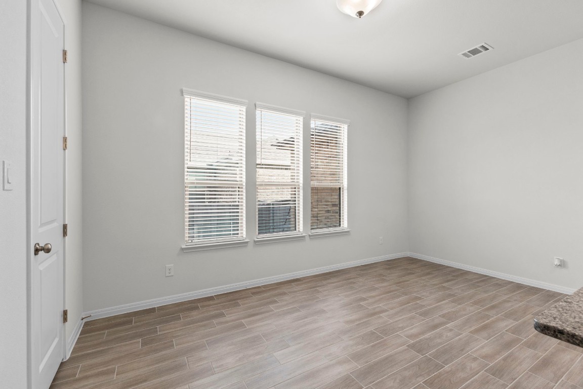 104 Scenic Hills Circle Georgetown, TX 78628 - Photo 12 of 30 a view of an empty room with wooden floor and a window