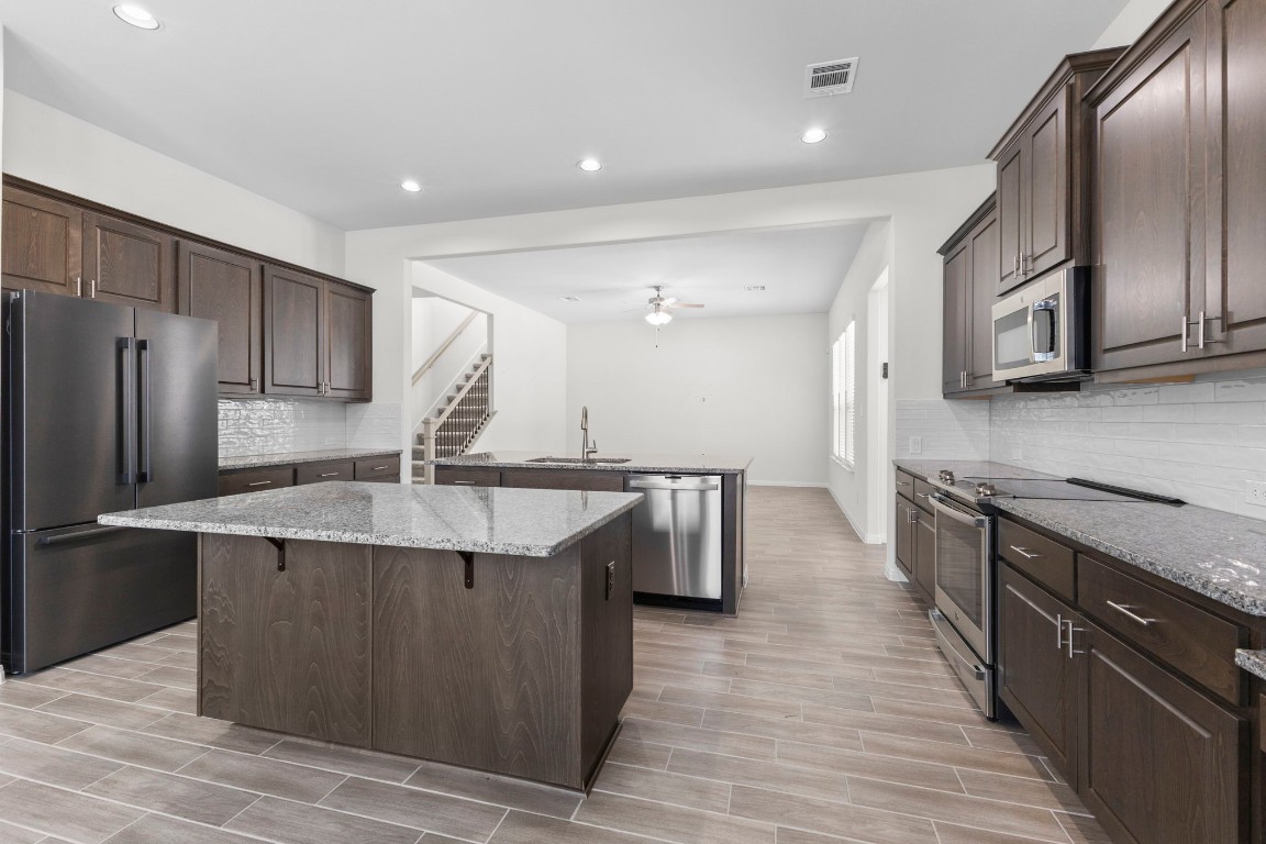 104 Scenic Hills Circle Georgetown, TX 78628 - Photo 13 of 30 a kitchen with stainless steel appliances granite countertop a sink a stove and a refrigerator