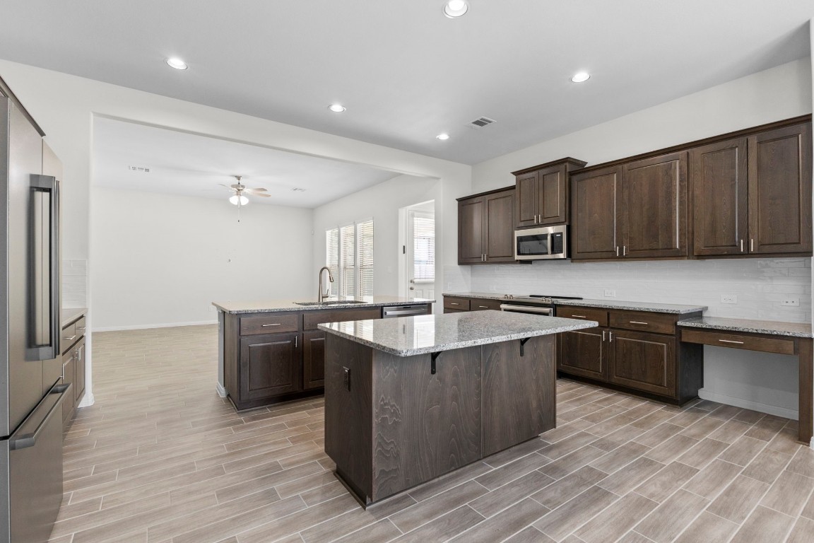 104 Scenic Hills Circle Georgetown, TX 78628 - Photo 16 of 30 a kitchen with stainless steel appliances granite countertop a sink stove and refrigerator