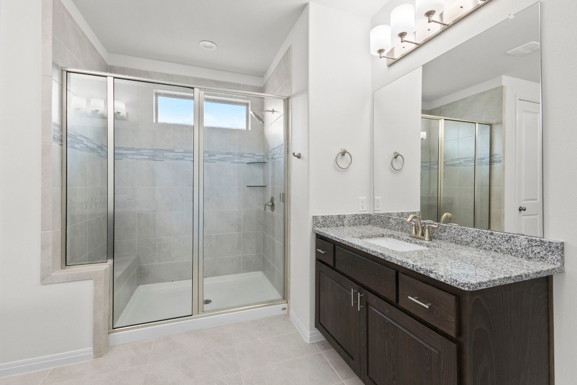 104 Scenic Hills Circle Georgetown, TX 78628 - Photo 20 of 30 a bathroom with a granite countertop sink a mirror and a shower