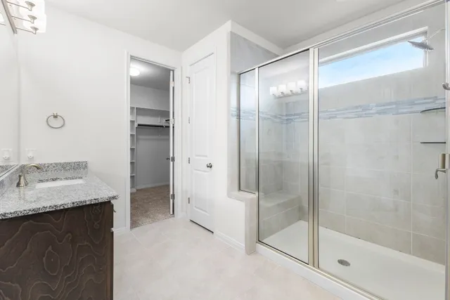 a bathroom with a granite countertop shower sink and mirror