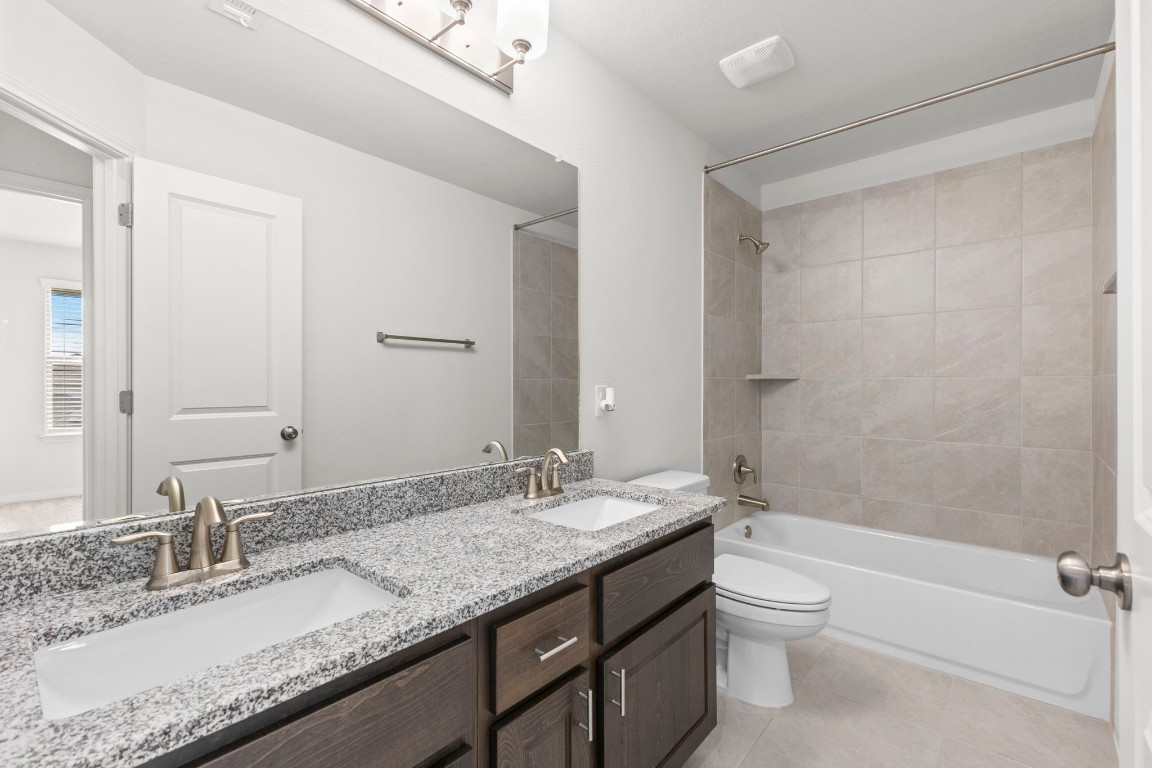 104 Scenic Hills Circle Georgetown, TX 78628 - Photo 26 of 30 a bathroom with a granite countertop sink a toilet and shower