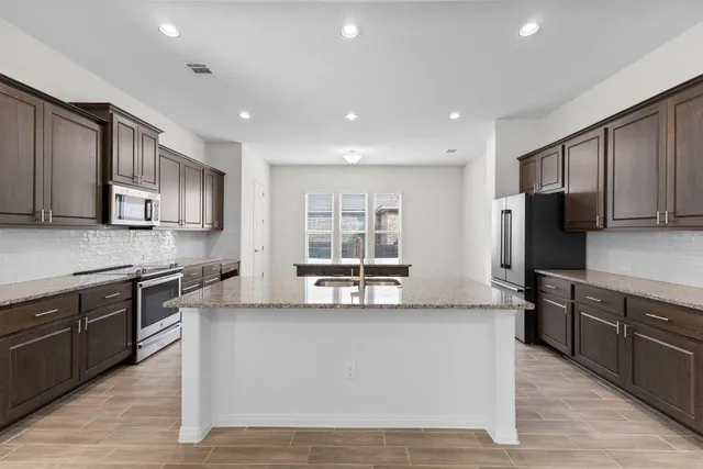 a large kitchen with stainless steel appliances lots of counter top space