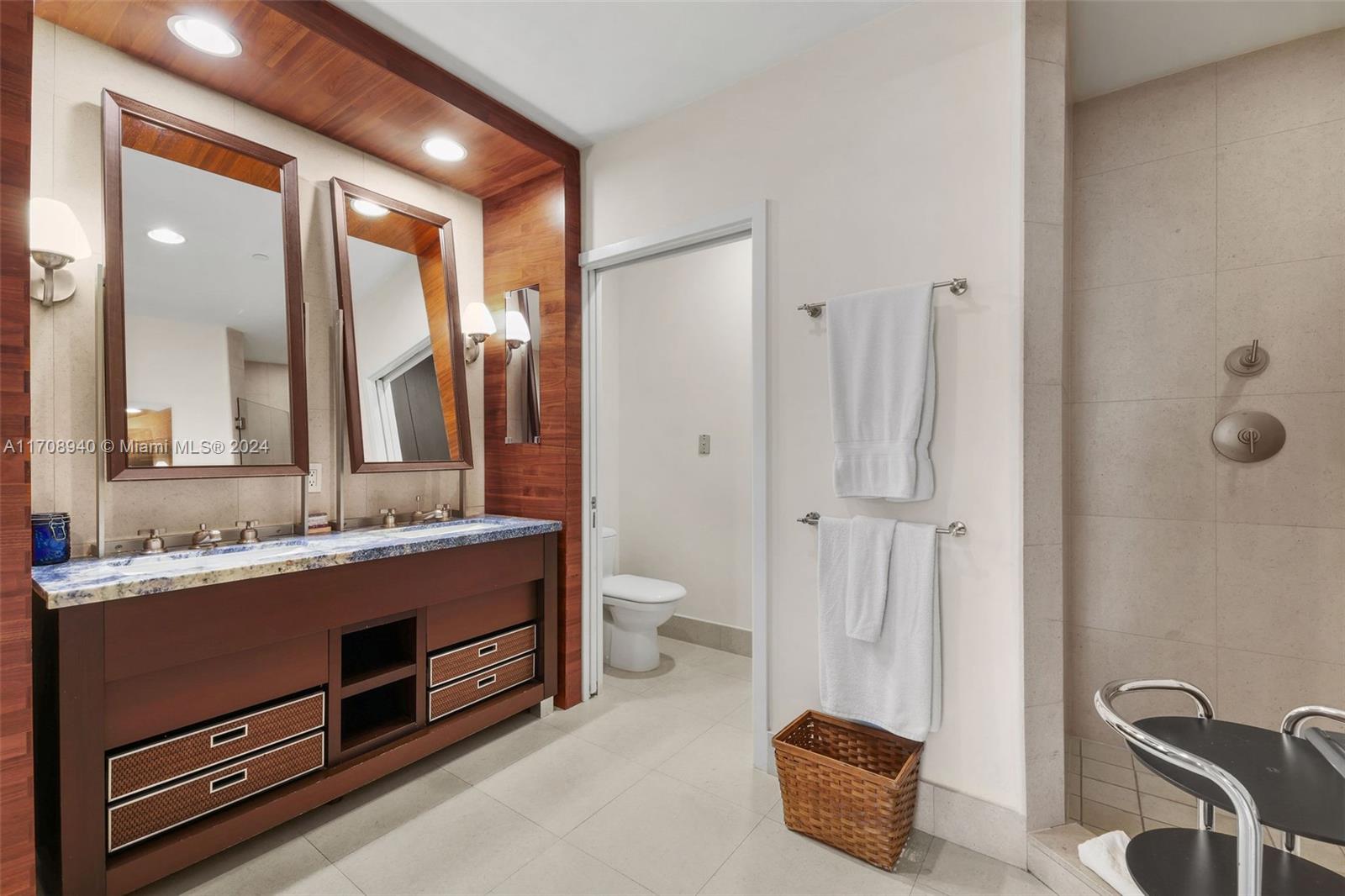 6799 Collins Avenue, Unit 207 Miami Beach, FL 33141 - Photo 18 of 35 a bathroom with a double vanity sink a toilet and a mirror