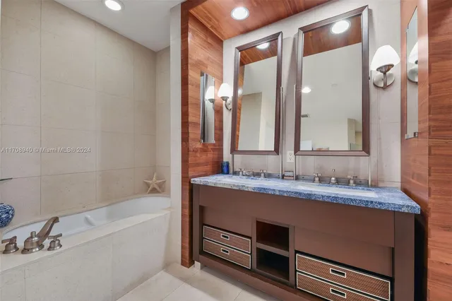 a bathroom with a tub sink and mirror