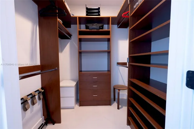 a view of walk in closet with clothes and shoes