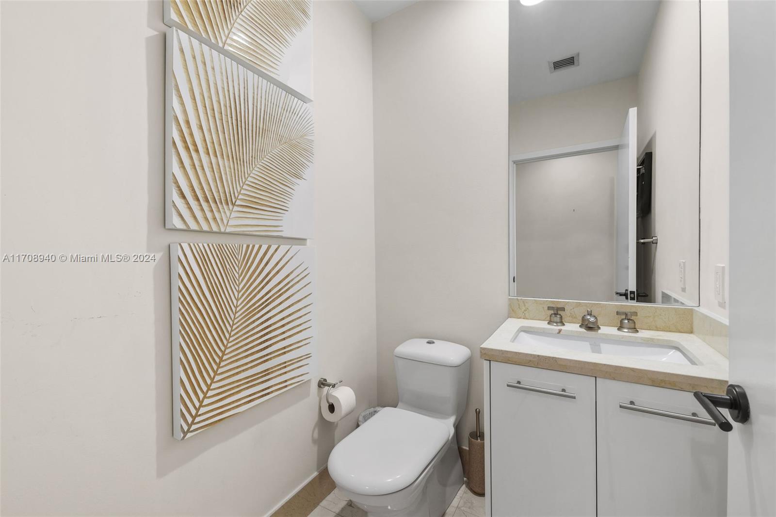 6799 Collins Avenue, Unit 207 Miami Beach, FL 33141 - Photo 24 of 35 a bathroom with a sink toilet and mirror