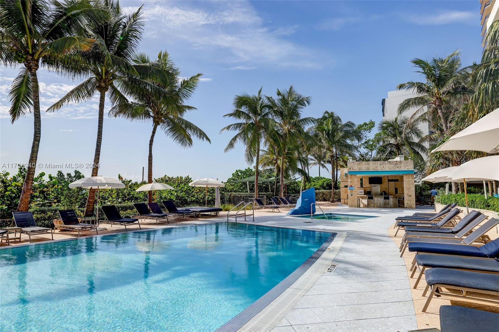 6799 Collins Avenue, Unit 207 Miami Beach, FL 33141 - Photo 27 of 35 a swimming pool with outdoor seating and a garden