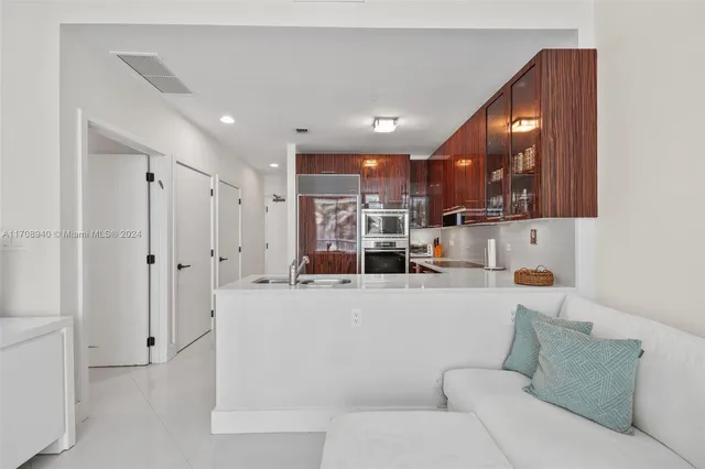 a living room with stainless steel appliances kitchen island a table and a couch