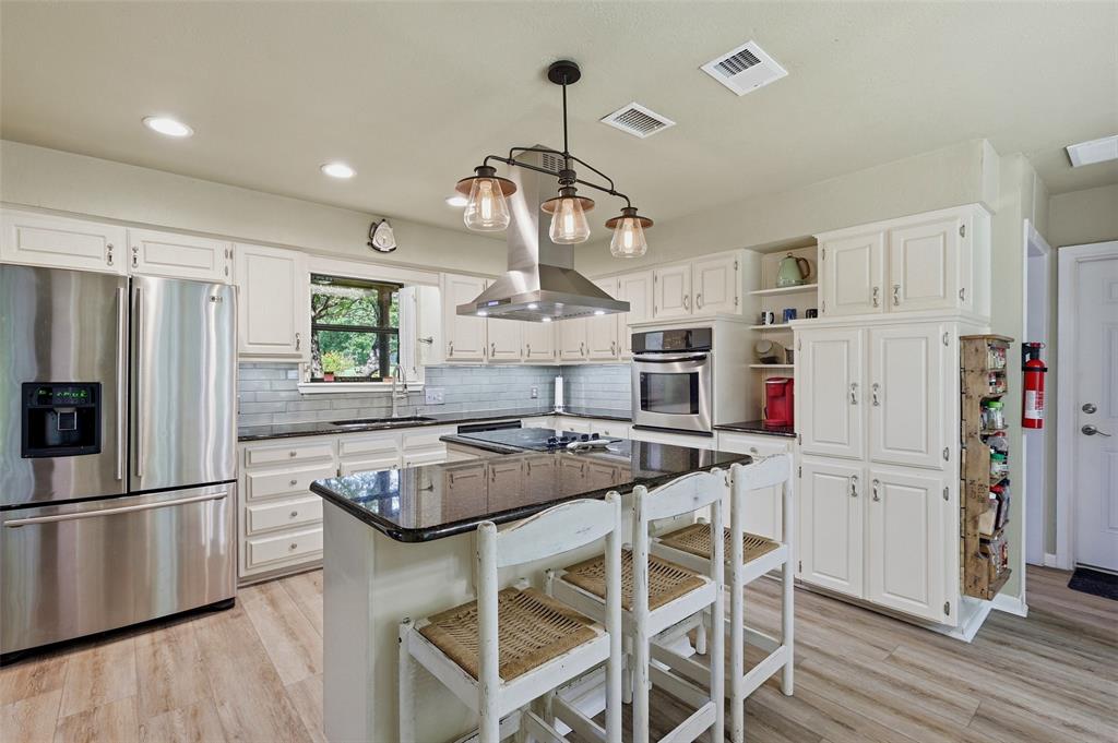 522 High Country Road Sherman, TX 75092 - Photo 9 of 38 a kitchen with stainless steel appliances granite countertop a refrigerator a sink dishwasher a stove and white cabinets with wooden floor