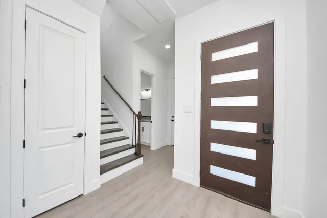 a view of a hallway with wooden floor and windows