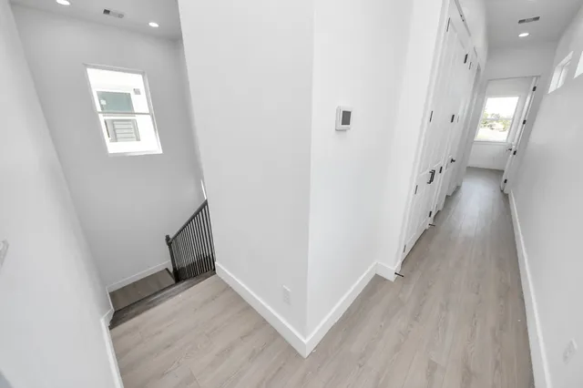 a view of a hallway with wooden floor and staircase
