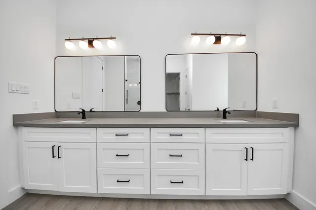 a spacious bathroom with a granite countertop sink mirror and shower