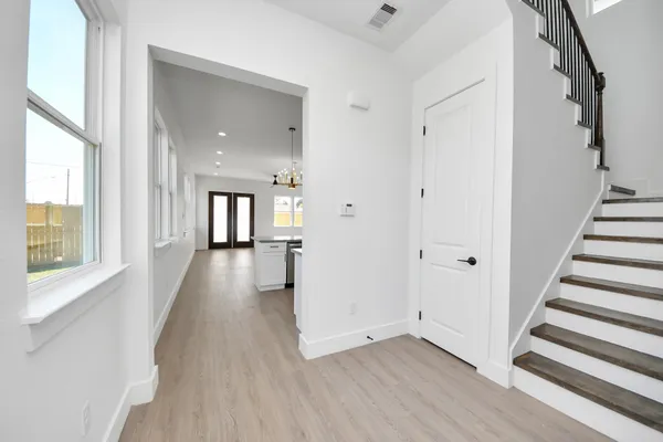 a view of a hallway with wooden floor and windows