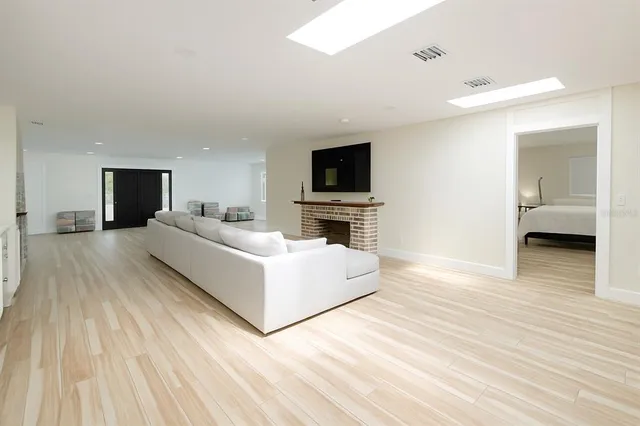 a kitchen with stainless steel appliances a stove top oven a sink dishwasher and a refrigerator with wooden floor