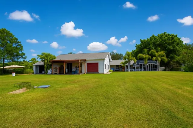 an aerial view of residential houses with outdoor space and trees all around