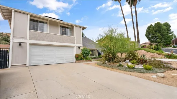 a backyard of a house with flower plants and trees