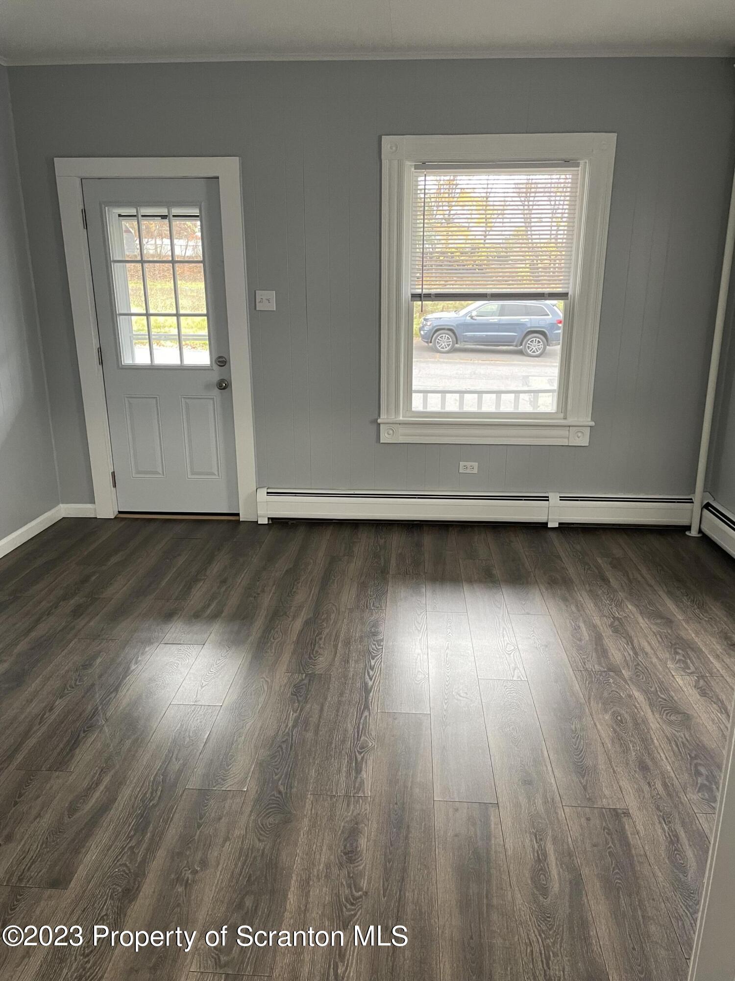 1311 Clay Avenue, Unit 1 Dunmore, PA 18510 - Photo 1 of 8 an empty room with wooden floor and windows