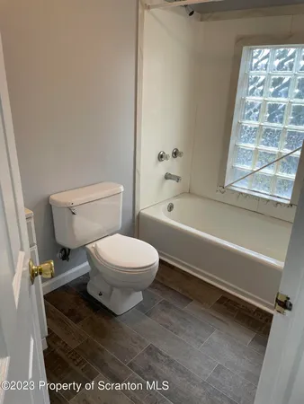 a white toilet sitting next to a bath tub