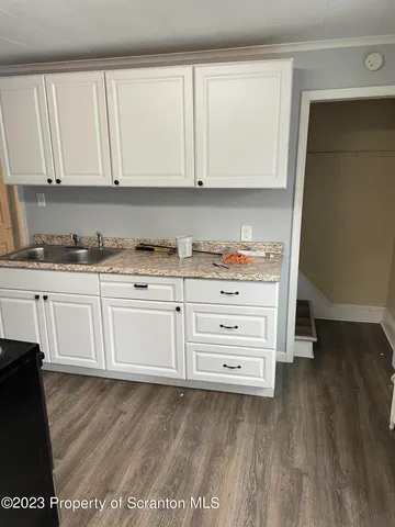 a kitchen with granite countertop white cabinets and sink