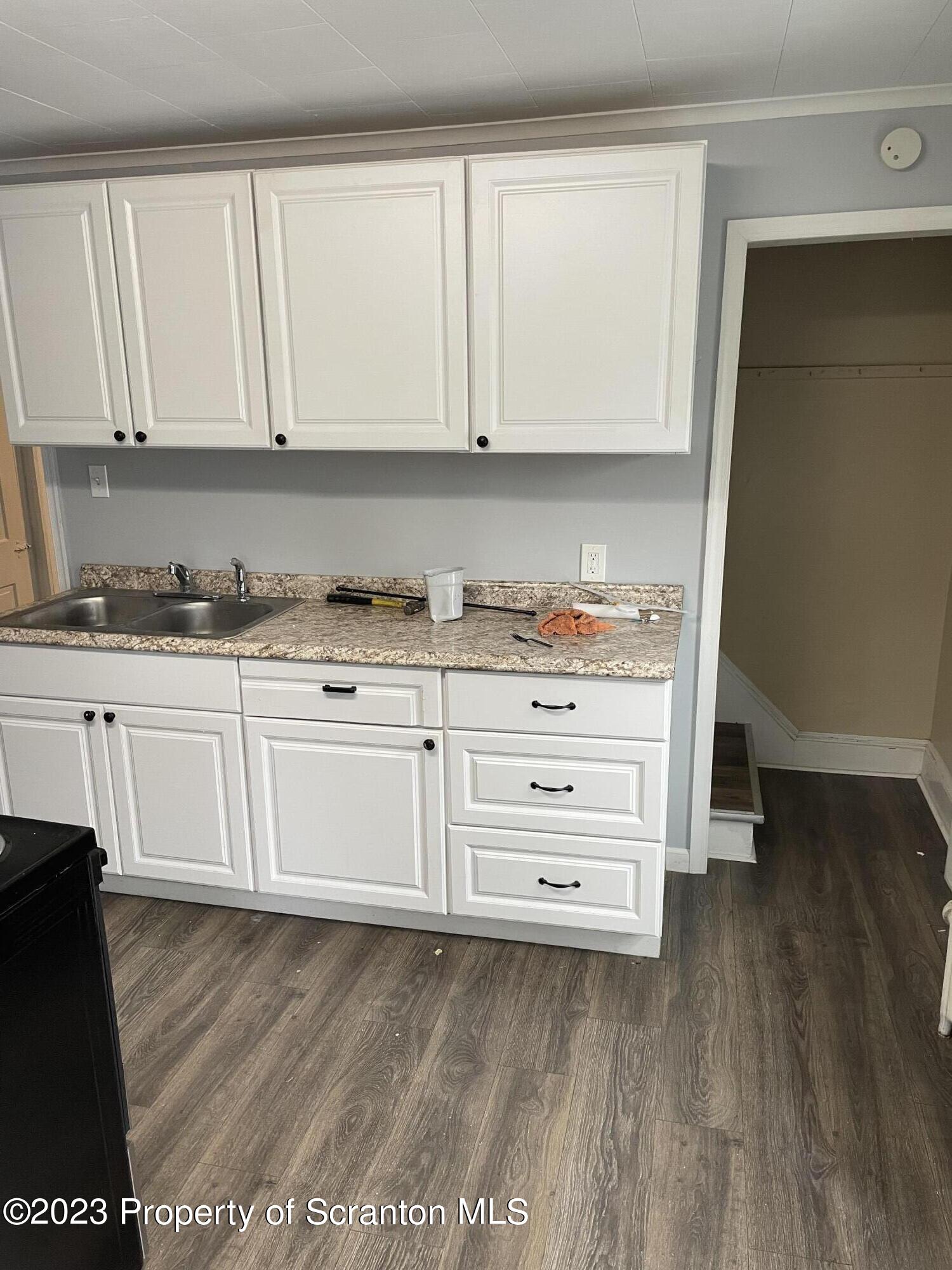 1311 Clay Avenue, Unit 1 Dunmore, PA 18510 - Photo 8 of 8 a kitchen with granite countertop white cabinets and sink