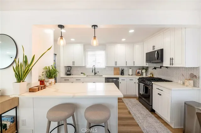a kitchen with appliances a sink and cabinets