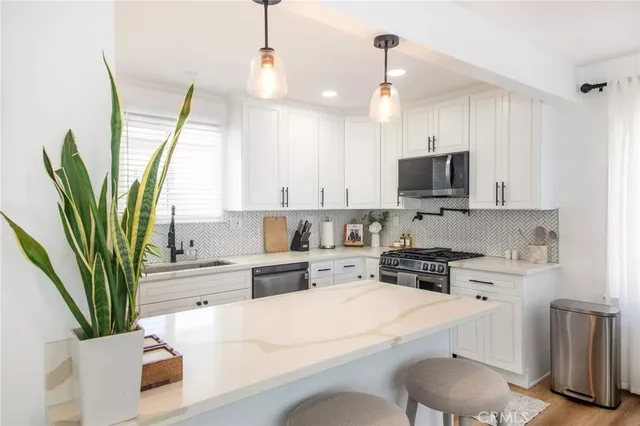 a kitchen with appliances a sink cabinets and a counter top space