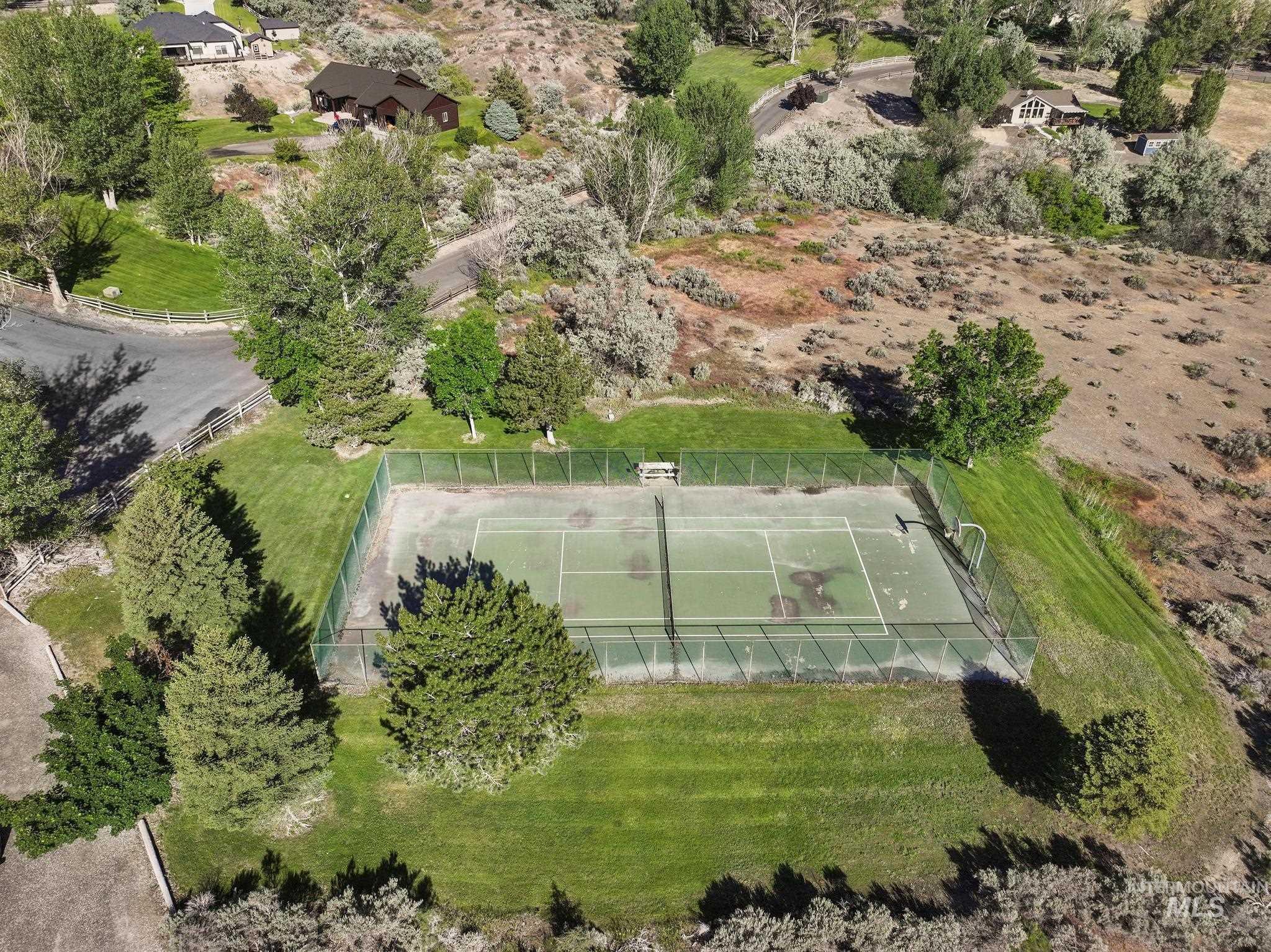 4485 Silver Creek Road Buhl, ID 83316 - Photo 43 of 49 Outdoor tennis court surrounded by mature trees, situated within a green lawn area
