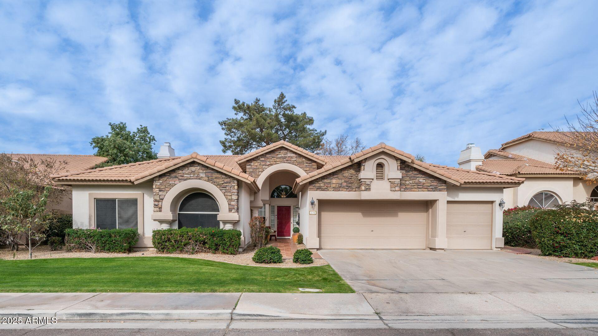 2214 East Beachcomber Drive Gilbert, AZ 85234 - Photo 1 of 45 a front view of a house with a garden and garage