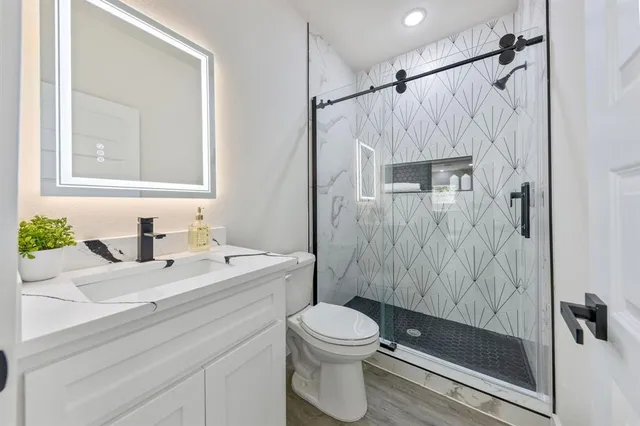 a bathroom with a sink a toilet and shower