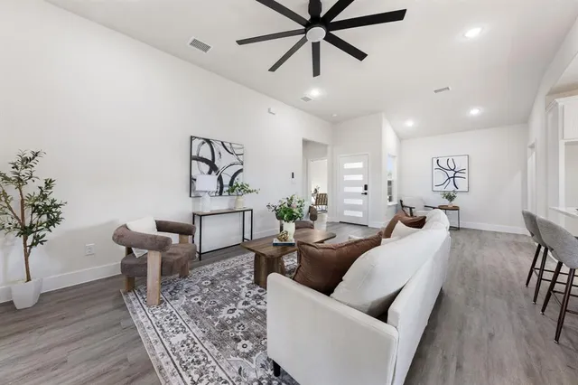 a living room with furniture and a wooden floor