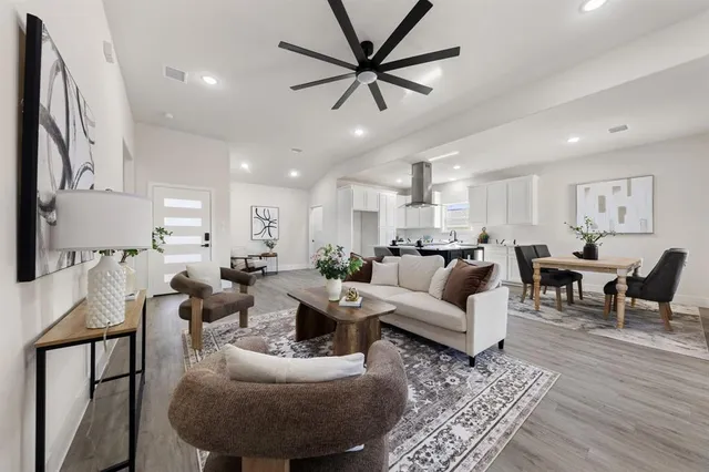 a living room with furniture kitchen view and a chandelier