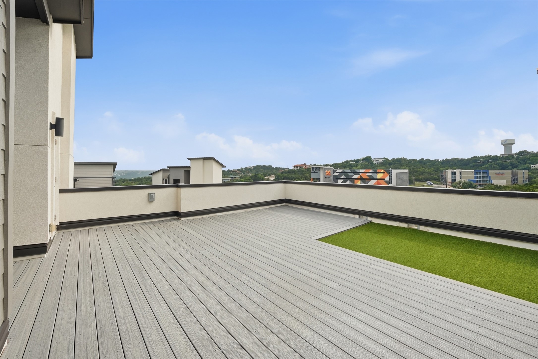 4300 Mansfield Dam Road, Unit 1021 Austin, TX 78734 - Photo 33 of 40 Rooftop deck featuring composite decking, integrated artificial turf, and stucco exterior walls