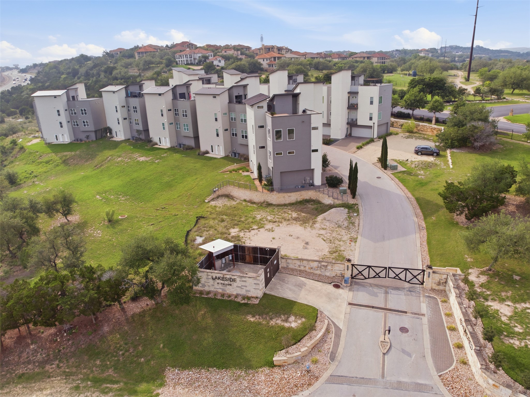 4300 Mansfield Dam Road, Unit 1021 Austin, TX 78734 - Photo 34 of 40 Modern residential complex featuring multi-level units with contemporary exterior finishes, private balconies, and integrated garages