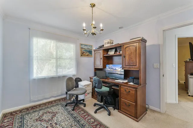 a view of a workspace with furniture and a window