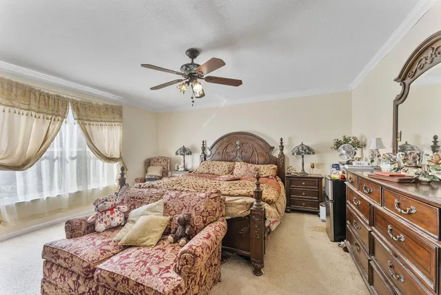a bedroom with a bed a chandelier and dresser