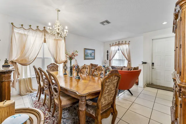 a view of a dining room with furniture a chandelier and wooden floor
