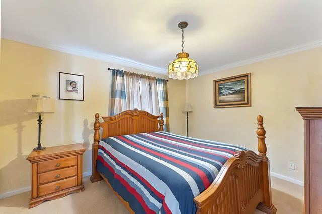 a bedroom with bed and a chandelier