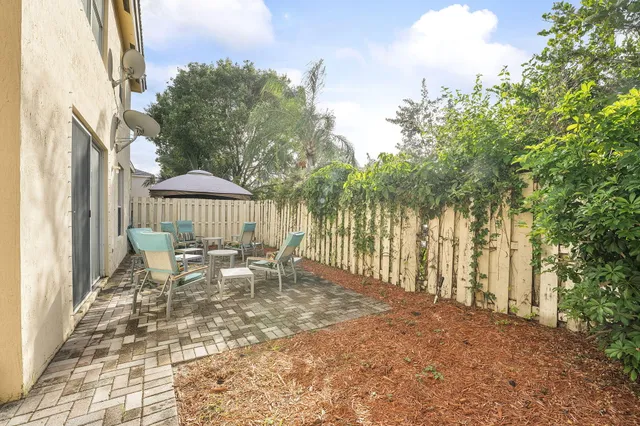 a view of a patio with table and chairs and floor to ceiling window