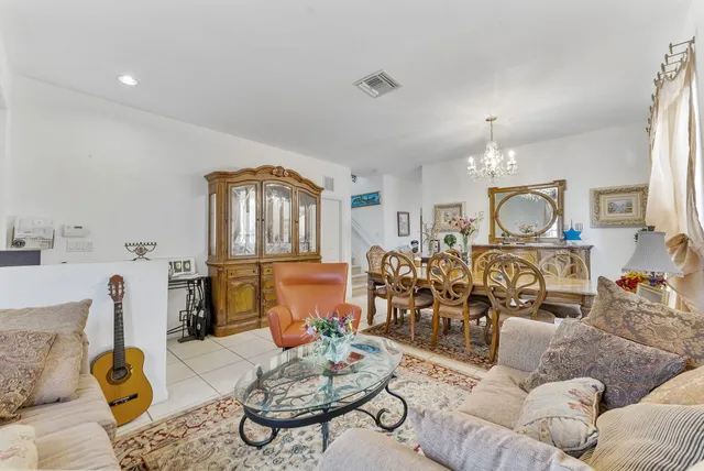 a living room with furniture chandelier and wooden floor