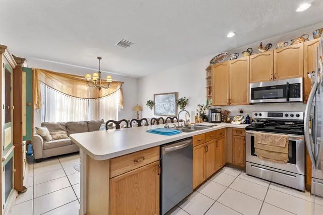 a large kitchen with kitchen island granite countertop a sink counter top space appliances and cabinets