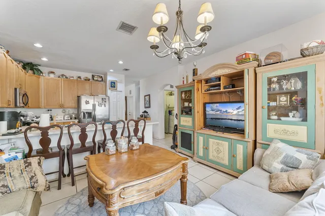a living room with furniture a chandelier and a flat screen tv
