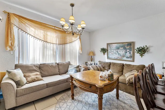 a living room with furniture a chandelier and a window