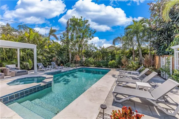a view of backyard with swimming pool and green space